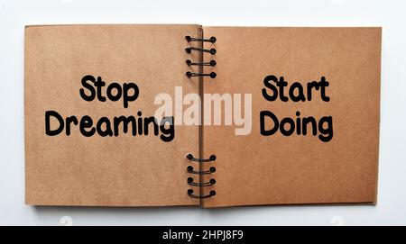 Aufhören zu träumen, anfangen zu tun, Anführungszeichen motivieren. Inspirierendes motivierendes Zitat auf Notizbuch. Stockfoto