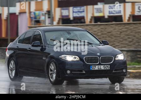 Side, Türkei - 02. Februar 2022: Die schwarze BMW Series 5 fährt an einem warmen Tag schnell auf der Straße Stockfoto