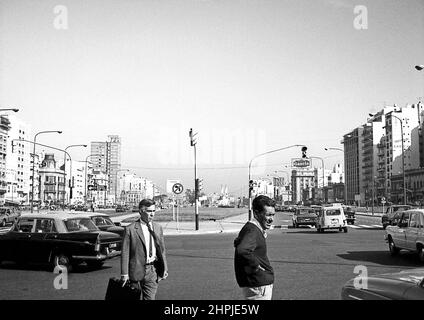 ARG 264b Buenos Aires Argentinien 1973 9th Juli Avenue und Stadtzentrum Verkehrsszene mit zwei Geschäftsleuten im Vordergrund Stockfoto