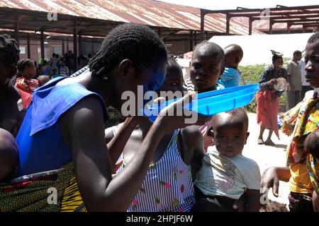 Im Bangula Camp im Bezirk Nsanje, Malawi, wird eine Frau gesehen, die Wasser aus dem Deckel eines Wassereimer trinkt. Tausende von Menschen leben im Lager, nachdem ihre Häuser durch den tropischen Wirbelsturm Ana zerstört wurden. Malawi. Stockfoto