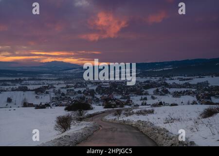 Bergstraße im verschneiten Winter bei einem herrlichen Sonnenuntergang Stockfoto
