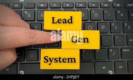 Draufsicht auf den Text des Lead Gen Systems auf gelben Holzblöcken mit Laptop-Hintergrund. Stockfoto