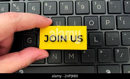 Draufsicht des Join US-Textes auf Holzblöcken mit Laptop-Hintergrund. Stockfoto