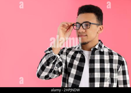 Junger Mann im karierten Hemd auf rosa Hintergrund Stockfoto