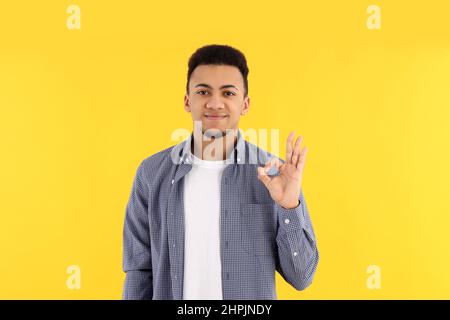 Junger Mann im karierten Hemd auf gelbem Hintergrund Stockfoto