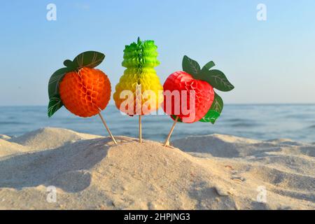 Bunte Figur Papierdekorationen für Cocktail am Sandstrand Stockfoto