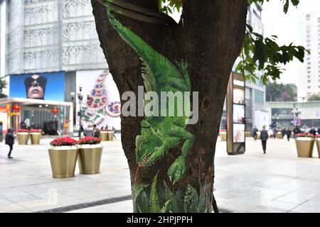 Chongqing, Chongqing, China. 22nd. Februar 2022. Am 22. Februar 2022 begann der ''Zoo'' auf dem Baum in der Jiefangbei-Fußgängerzone in Chongqing.vor kurzem, in der Jiefangbei des Yuzhong-Bezirks, Chongqing, wo beliebte Check-in-Punkte gesammelt werden, hat ein ''Zoo'' auf einem Baum begonnen, Aufmerksamkeit zu erregen. Der Reporter sah auf der Minzu Road, der Jiefangbei Fußgängerzone, dass in der Mitte der geraden Straße zwei Reihen von dichten gelben Wacholderbäumen sind. Mehr als ein Dutzend Tiere, darunter das ''Lightning''-Faultier in ''Zootopia'' und das ''Timan''-Erdmännchen in ''The Lion King''. Die Gemälde sind lebensecht und Stockfoto