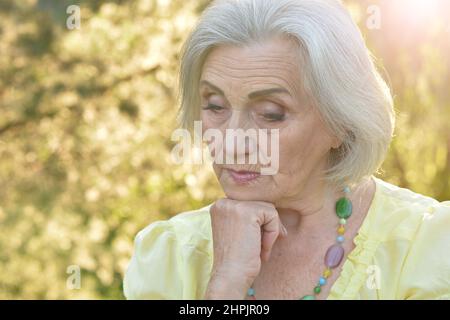 Portrait von traurigen Senior schöne Frau im Park Stockfoto