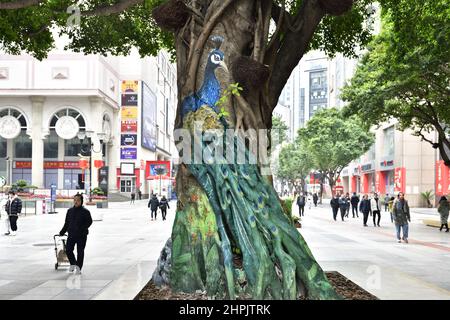 Chongqing, Chongqing, China. 22nd. Februar 2022. Am 22. Februar 2022 begann der ''Zoo'' auf dem Baum in der Jiefangbei-Fußgängerzone in Chongqing.vor kurzem, in der Jiefangbei des Yuzhong-Bezirks, Chongqing, wo beliebte Check-in-Punkte gesammelt werden, hat ein ''Zoo'' auf einem Baum begonnen, Aufmerksamkeit zu erregen. Der Reporter sah auf der Minzu Road, der Jiefangbei Fußgängerzone, dass in der Mitte der geraden Straße zwei Reihen von dichten gelben Wacholderbäumen sind. Mehr als ein Dutzend Tiere, darunter das ''Lightning''-Faultier in ''Zootopia'' und das ''Timan''-Erdmännchen in ''The Lion King''. Die Gemälde sind lebensecht und Stockfoto