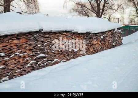 Holzreste von Brettern unter einer dicken Schneeschicht. Stockfoto