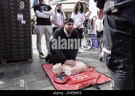 Jerusalem, Israel. 22nd. Februar 2022. Sanitäter von Magen David Adom, Israels führendem Rettungsdienst, demonstrieren und unterweisen am 22nd. Februar auf dem Shuk Mahane Yehuda Markt den Einsatz von HLW und Defibrillatoren und ihre Bedeutung für die Rettung von Menschenleben. Tausende von Defibrillatoren sind landesweit installiert und für den Einsatz an öffentlichen Orten verfügbar. Kredit: Nir Alon/Alamy Live Nachrichten Stockfoto