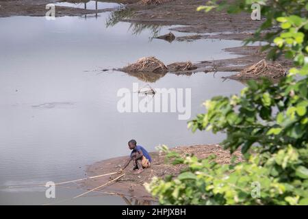 Ein Junge wird gesehen, wie er in Überschwemmungsgewässern fischt, die den Chikwawa-Bezirk in Malawi umspülten. Der tropische Wirbelsturm Ana überflutete den Bezirk und zerstörte viele Häuser. Malawi. Stockfoto