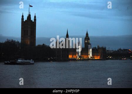 Der berühmte britische Palast von Westminster steht stolz an der Themse auf diesem Foto, das in der Dämmerung gegen einen blauen Himmel aufgenommen wurde Stockfoto