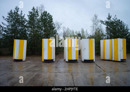 Strandtoiletten. Gelbe bewegliche Strangtoiletten in einer Reihe. Freundlich Stockfoto