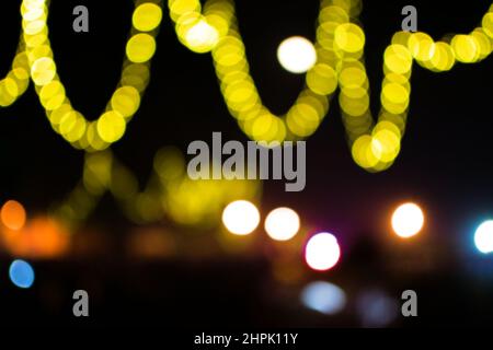 Bokeh Licht der gelben Farbe in geschwungenen Formen mit schwarzem Hintergrund während eines besonderen Anlasses des Festivals. Stockfoto