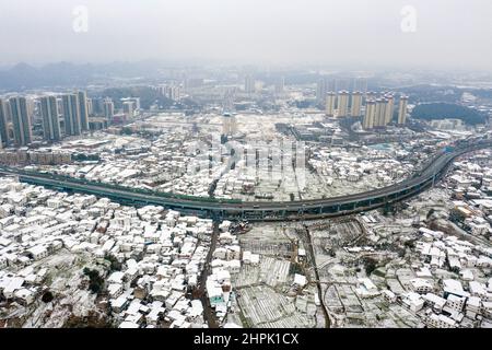 Guiyang. 22nd. Februar 2022. Luftaufnahme vom 22. Februar 2022 zeigt die Schneelandschaft einer wirtschaftlichen und technologischen Entwicklungszone in der Stadt Guiyang, südwestlich der chinesischen Provinz Guizhou. Chinas meteorologische Behörden haben am Dienstag in einigen Regionen des Landes weiterhin eine gelbe Warnung für starken Schnee ausgegeben. Von Dienstagmorgen bis Mittwochmorgen werden Schneestürme Teile von Yunnan, Guizhou, Hunan, Jiangxi, Anhui und Zhejiang treffen. Laut dem National Meteorological Center werden bis zu 25 Millimeter Schneefall erwartet. Kredit: Ou Dongqu/Xinhua/Alamy Live Nachrichten Stockfoto