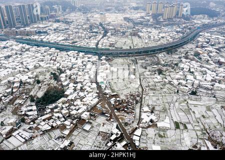 Guiyang. 22nd. Februar 2022. Luftaufnahme vom 22. Februar 2022 zeigt die Schneelandschaft einer wirtschaftlichen und technologischen Entwicklungszone in der Stadt Guiyang, südwestlich der chinesischen Provinz Guizhou. Chinas meteorologische Behörden haben am Dienstag in einigen Regionen des Landes weiterhin eine gelbe Warnung für starken Schnee ausgegeben. Von Dienstagmorgen bis Mittwochmorgen werden Schneestürme Teile von Yunnan, Guizhou, Hunan, Jiangxi, Anhui und Zhejiang treffen. Laut dem National Meteorological Center werden bis zu 25 Millimeter Schneefall erwartet. Kredit: Ou Dongqu/Xinhua/Alamy Live Nachrichten Stockfoto