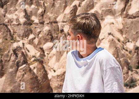 Teenager vor den Felsformationen von Kappadokien in der Türkei mit einer fabelhaften und Wüstenlandschaft. Stockfoto