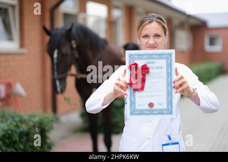 Weibliche Tierärztin mit Zertifikat für die Weiterbildung in der Tierklinik Stockfoto