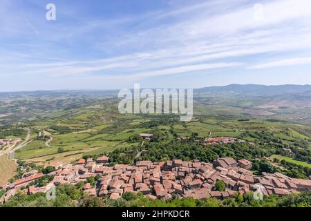 Altes toskanisches Ziegeldächer Dorf Radicofani in Italien mit langer entfernter Perspektive der toskanischen Hügel (Val d'Orcia) Stockfoto