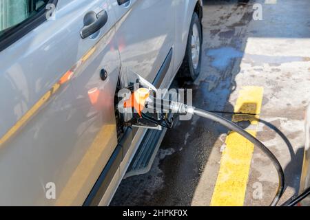 Die Zapfpistole am Fahrzeug füllt Kraftstoff in das Fahrzeug ein. Pumpen von Kraftstoff für ein Auto. Hochwertige Fotos Stockfoto