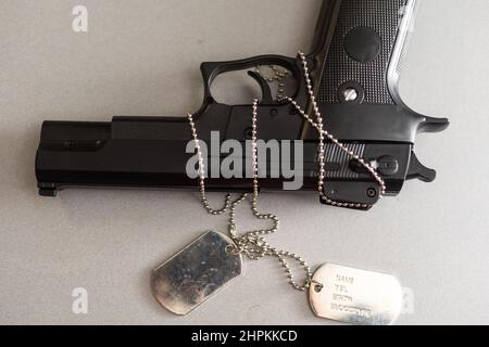 Pistole mit Dogtags. Konzept von Dienst und Dienst in US-Streitkräfte. Veteranenkonzept Stockfoto