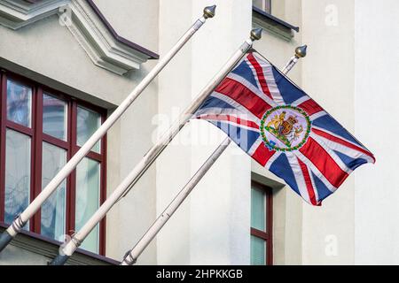 MINSK, WEISSRUSSLAND - 20. FEBRUAR 2022: Flagge des Vereinigten Königreichs von Großbritannien mit dem Wappen auf dem Botschaftsgebäude in Belarus Stockfoto