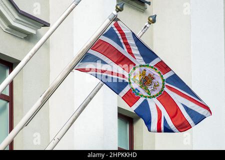 MINSK, WEISSRUSSLAND - 20. FEBRUAR 2022: Flagge des Vereinigten Königreichs von Großbritannien mit dem Wappen auf dem Botschaftsgebäude in Belarus Stockfoto