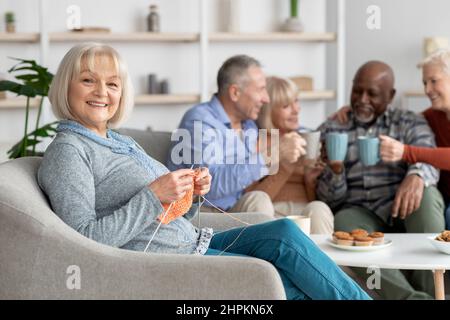 Attraktive ältere Dame, die im Pflegeheim strickt Stockfoto
