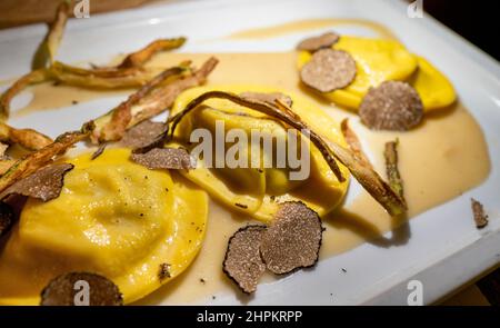 Italienische Küche, frisch hausgemachte rote Kartoffel gefüllte Pasta Tortellacci oder Ravioli Knödel mit sommerlichen schwarzen Trüffeln und knusprigen grünen Spargel, Parma, E Stockfoto