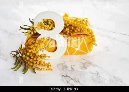 Gruß zum Internationalen Frauentag am 8th. März. Zweige der Mimose und Zahl acht. Stockfoto