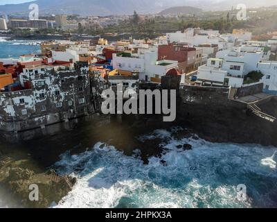 Luftaufnahme auf bunte Häuser und schwarze Lavasteine im kleinen Fischerdorf Punta Brava in der Nähe von Puerto de la Cruz, Teneriffa, Kanarische Inseln im Winter Stockfoto