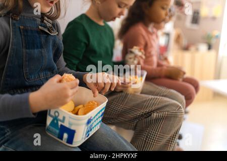 Gruppe von Klassenkameraden, die während der Schulpause einen Obstsnack essen. Stockfoto