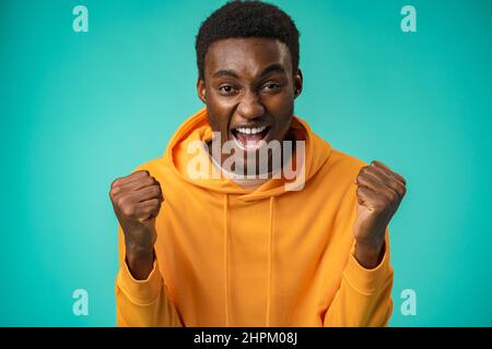 Porträt eines überglücklich schwarzen Mannes, der im Studio Erfolg feiert Stockfoto