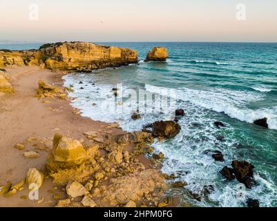 Luftaufnahme der Klippen am Strand von Sao Rafael am Atlantischen Ozean bei Sonnenuntergang, Algarve, Portugal Stockfoto