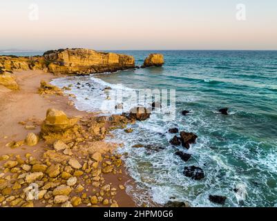 Luftaufnahme der Klippen am Strand von Sao Rafael am Atlantischen Ozean bei Sonnenuntergang, Algarve, Portugal Stockfoto