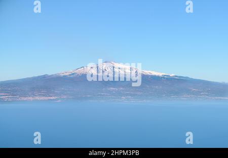 Luftaufnahme des Ätna, eines aktiven Vulkans in Sizilien, mit schneebedeckter Bergspitze und Catania Stadt, aus dem Mittelmeer Stockfoto