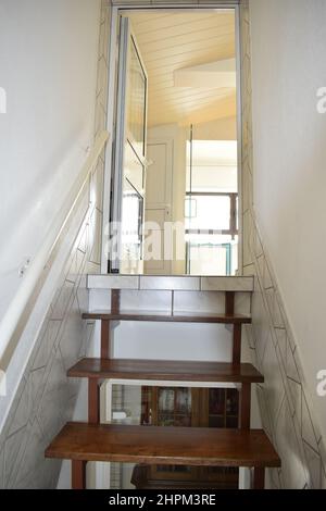 Schmale dunkle Treppe zu einer weißen Wohnung Stockfoto