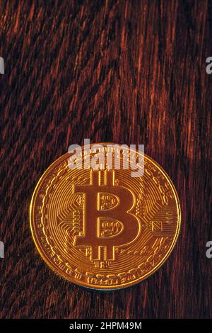 Bitcoin-Münze auf dunklem Holzhintergrund Stockfoto