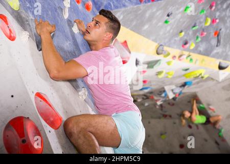 Mann trainiert in der Boulderhalle Stockfoto