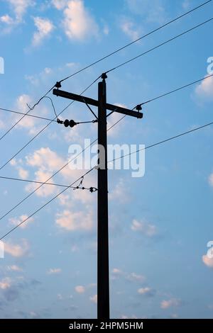 Nahaufnahme des Stromübertragungsmastes unter dem blauen Himmel am Abend Stockfoto