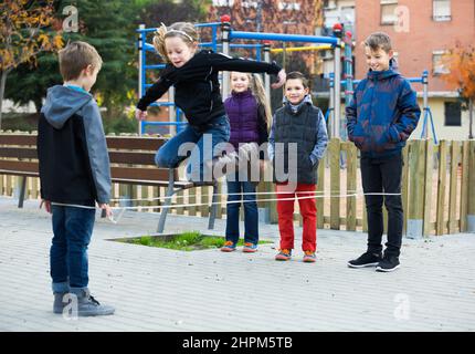 Gewöhnliche Kinder springen auf Springseil Stockfoto