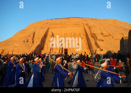 Assuan, Ägypten. 22nd. Februar 2022. Menschen treten auf, um das Sonnenfest im Großen Tempel von Abu Simbel in Assuan, Ägypten, zu feiern, 22. Februar 2022. Während des Sonnenfestes versammeln sich die Massen vor Sonnenaufgang, um das Sonnenlicht zu beobachten, das die innersten Skulpturen wie König Ramses II. Aufhellt Die innersten Skulpturen bleiben das ganze Jahr über im Großen Tempel von Abu Simbel in Dunkelheit, außer am 22. Februar und 22. Oktober, wenn das Sonnenlicht auf den Skulpturen zum Gedenken an die Krönung und den Geburtstag des Königs fällt. Quelle: Sui Xiankai/Xinhua/Alamy Live News Stockfoto