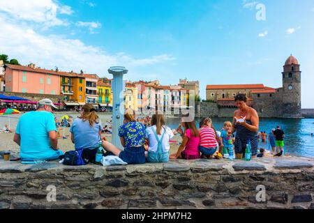 Collioure, Frankreich, Region Perpignan, Touristenbesuche, Straßenszenen, auf der Wand sitzen und die Strandszene betrachten, Lifestyle Teenager Stockfoto