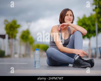 Outdoor-Sport, Workout und Wellness-Konzept. asiatische junge starke, selbstbewusste Frau in sportlicher Kleidung Entspannung nach dem Fitness-Workout in Park. Läuferin, die eine Pause vom Laufsport einnahm. Stockfoto