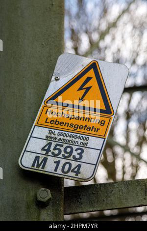 Lebensgefahr durch Hochspannung, Warnschild an einem Pylon der Freileitung Stockfoto