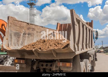 Muldenkipper mit einem Sandhaufen in der hinteren Konstruktion gewaschen Erdarbeiten vor Ort. Stockfoto