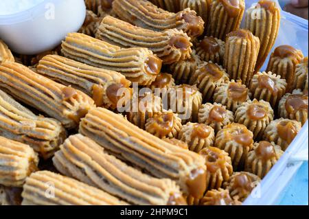 Peruanische Straßenchurros auf einer Plastikbox gestapelt Stockfoto