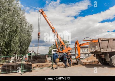 Weißrussland, Region Minsk - 20. Mai 2020: Ein Vorarbeiter in Overalls und ein Schutzhelm kontrolliert den Arbeitsprozess auf der Baustelle eines Industriezweiges Stockfoto