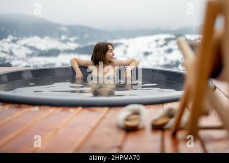 Frau, die im Whirlpool in den Bergen badete Stockfoto